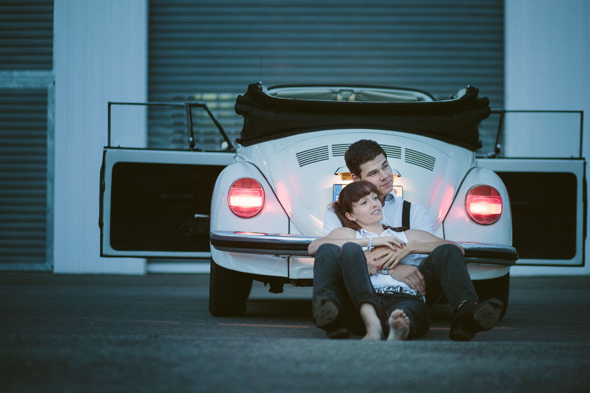 Paar lehnt an VW Käfer Cabrio