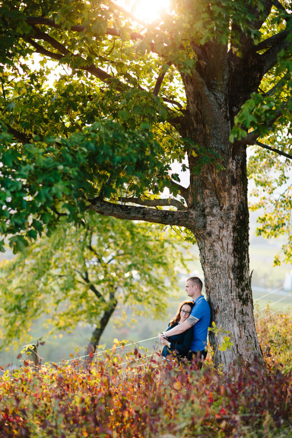 Paar steht an Baum gelehnt, Herbst