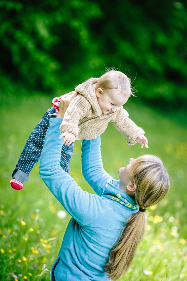 Kind wird von Mutter hochgeworfen und lacht