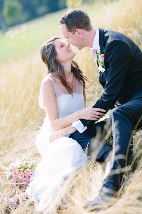 Brautpaar küsst sich im hohen Gras
